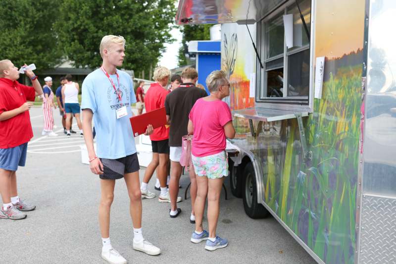 a group of people standing in front of a food truck