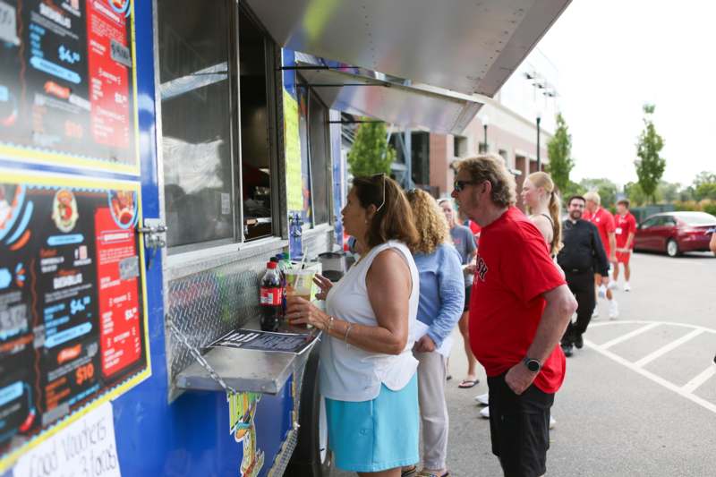 a group of people standing in line at a food truck