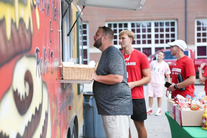 a man standing in front of a food truck