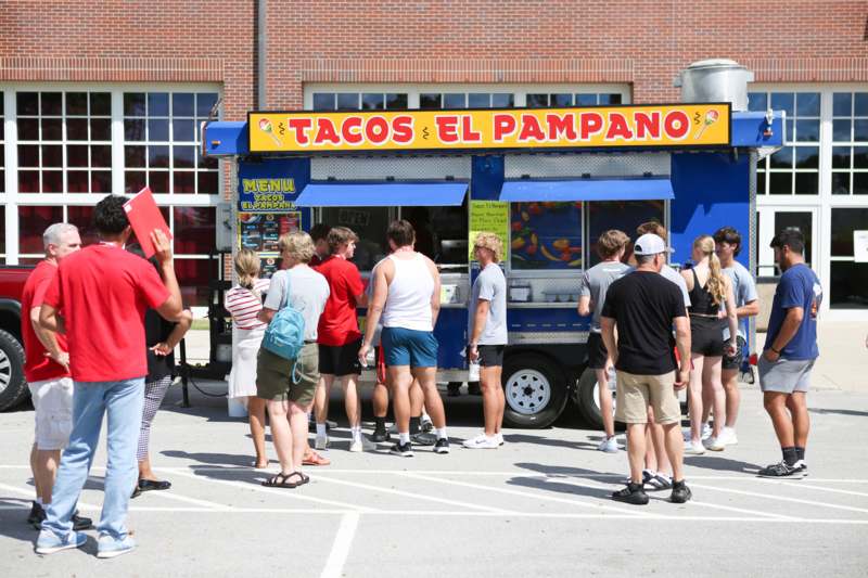 a group of people standing in front of a food truck