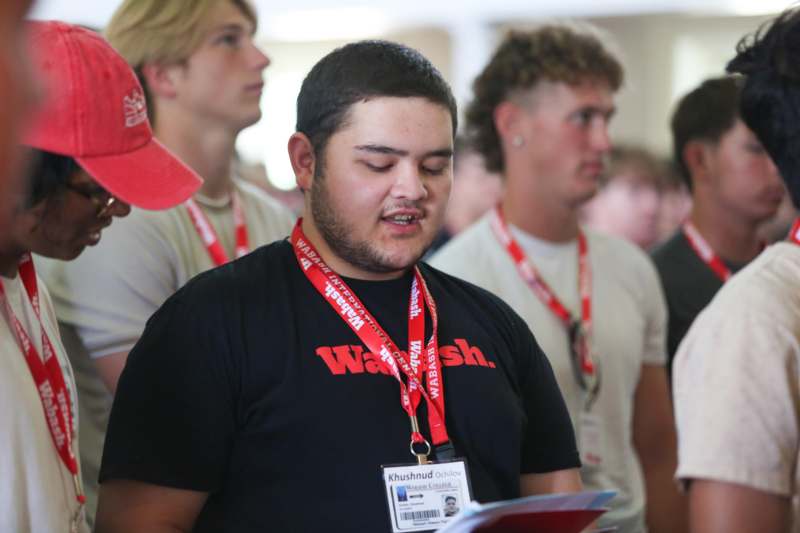 a man wearing lanyards and a black shirt