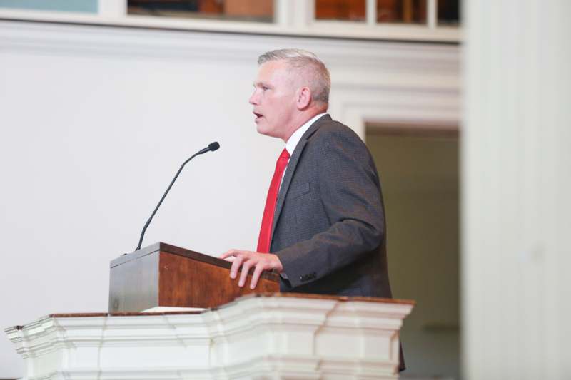 a man standing at a podium with a microphone