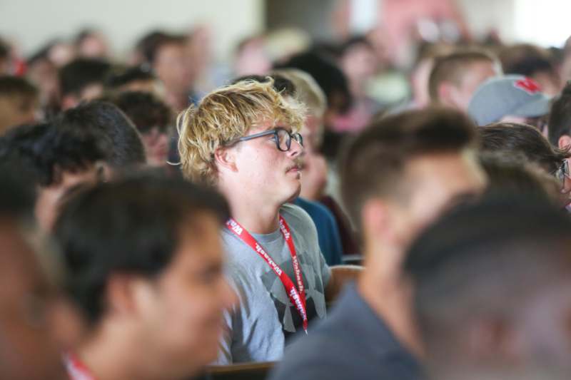 a man sitting in a room with a group of people