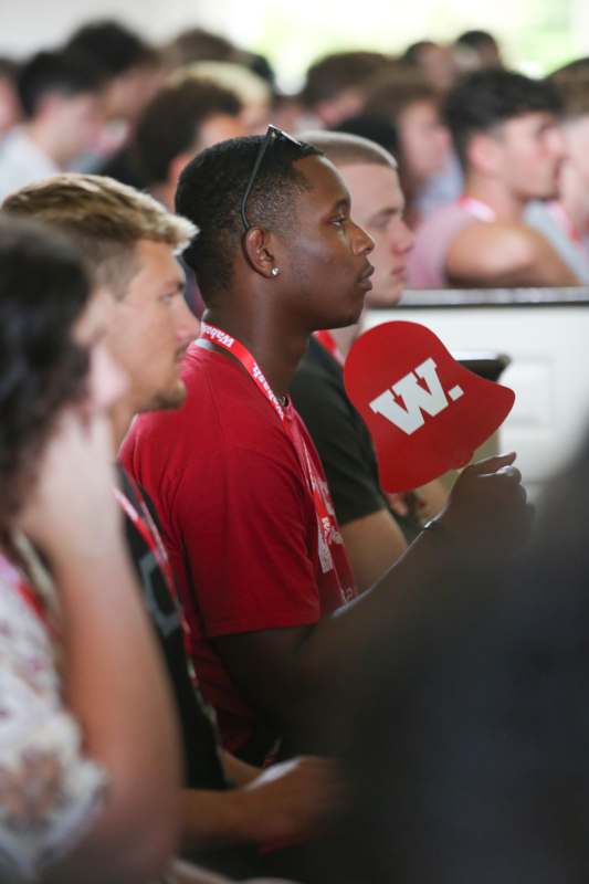 a man in a red shirt holding a red hat