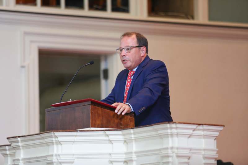 a man in a suit standing at a podium