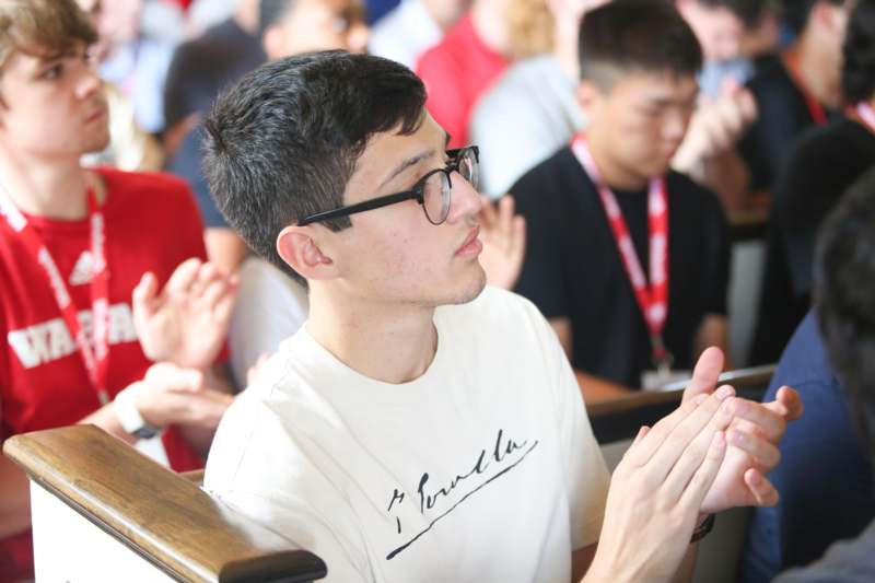 a man in glasses with his hands together