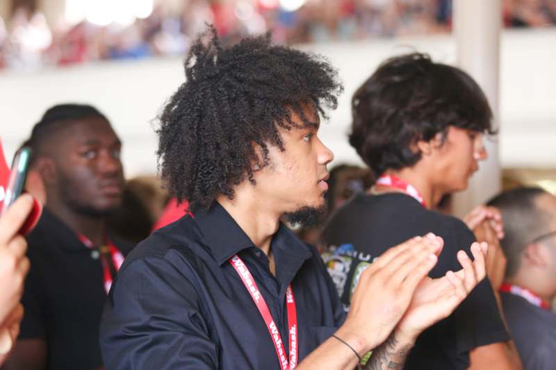 a man with curly hair clapping