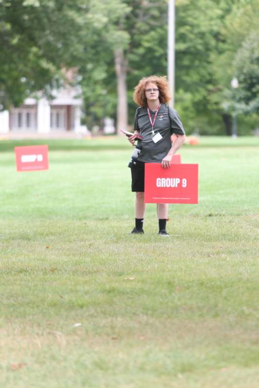 a woman holding a sign in a field