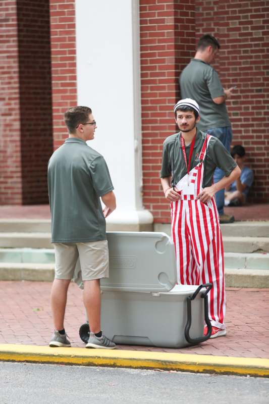 a man standing next to a cooler