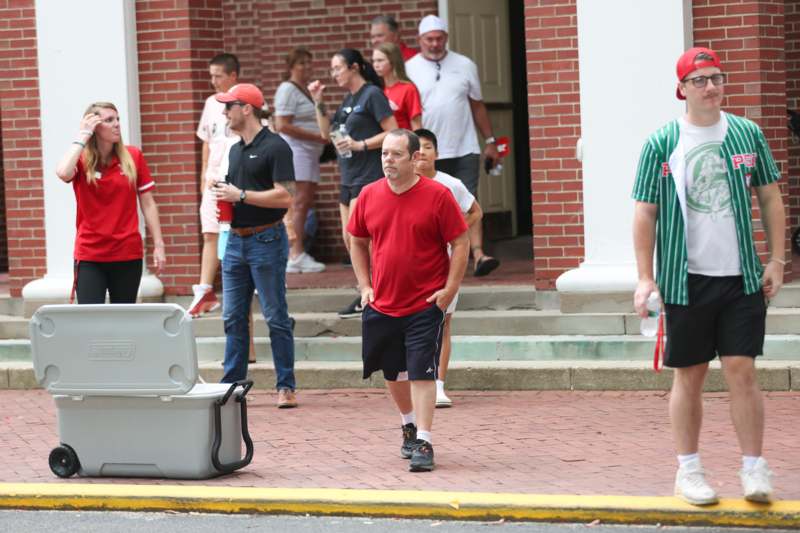 a group of people walking on a brick sidewalk