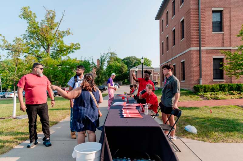 a group of people standing around a table