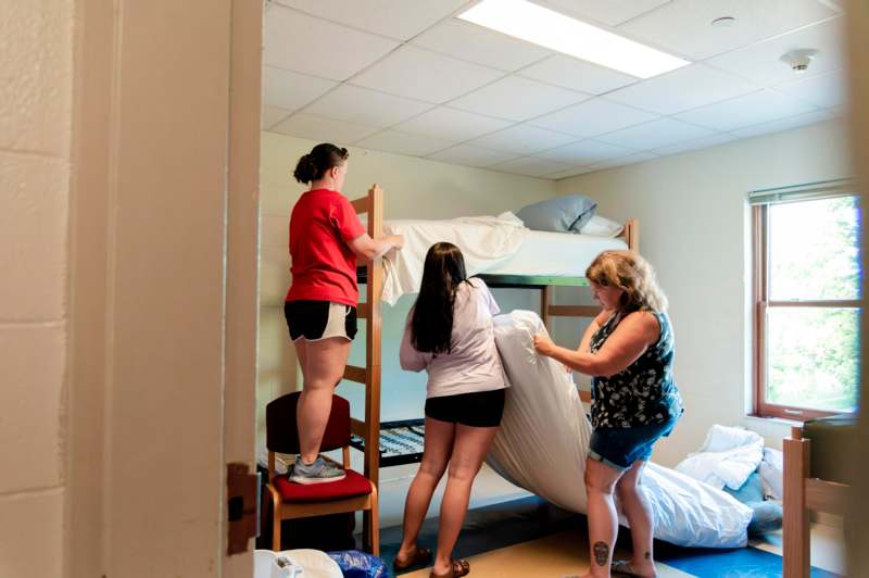 a group of women moving a bed