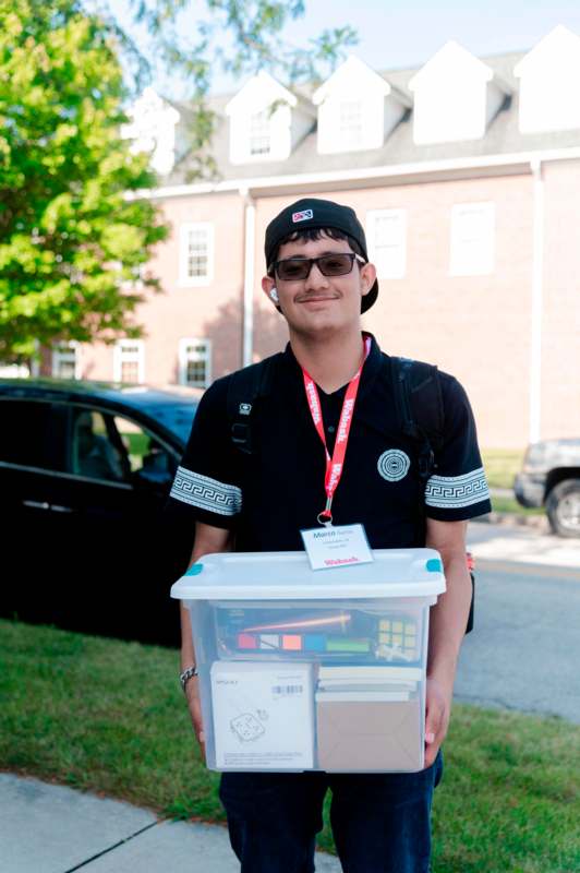 a man holding a plastic container with items in it