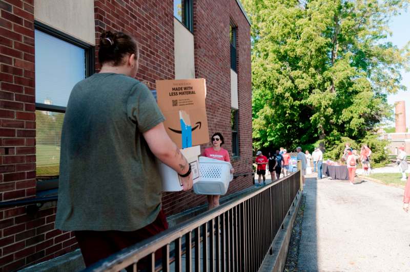 a woman carrying boxes and a laundry basket