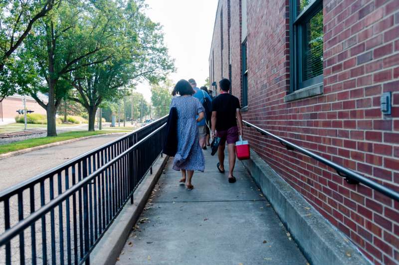 a group of people walking down a sidewalk