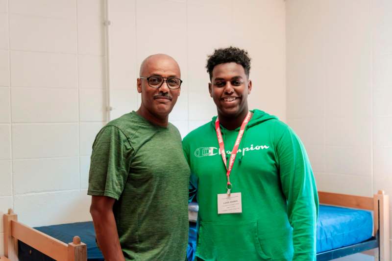 a man standing next to a man wearing a name tag