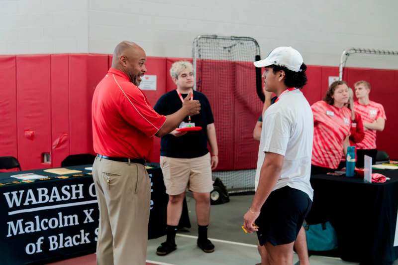 a man talking to a man in a white hat