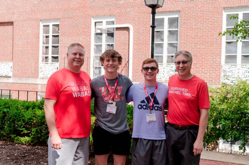 a group of men standing in front of a brick building