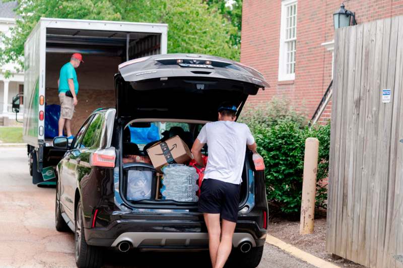 a man loading luggage into a car