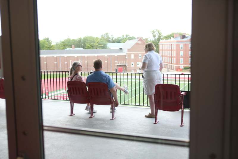 a group of people sitting on chairs looking out a window