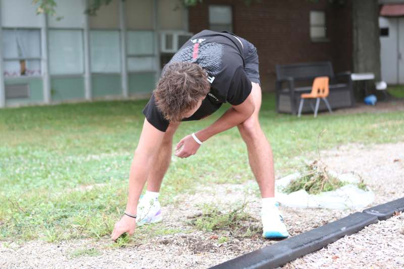 a man bending over in the grass