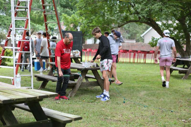 a group of people standing around a picnic table