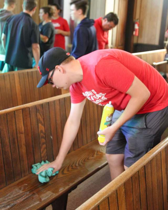 a man cleaning a pew