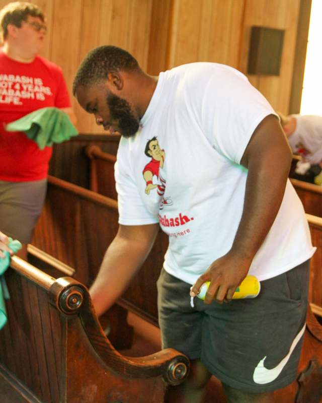 a man cleaning a pew