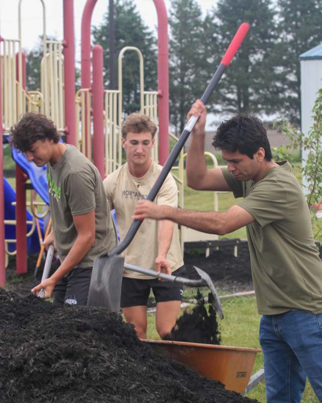 a group of men digging in a wheelbarrow