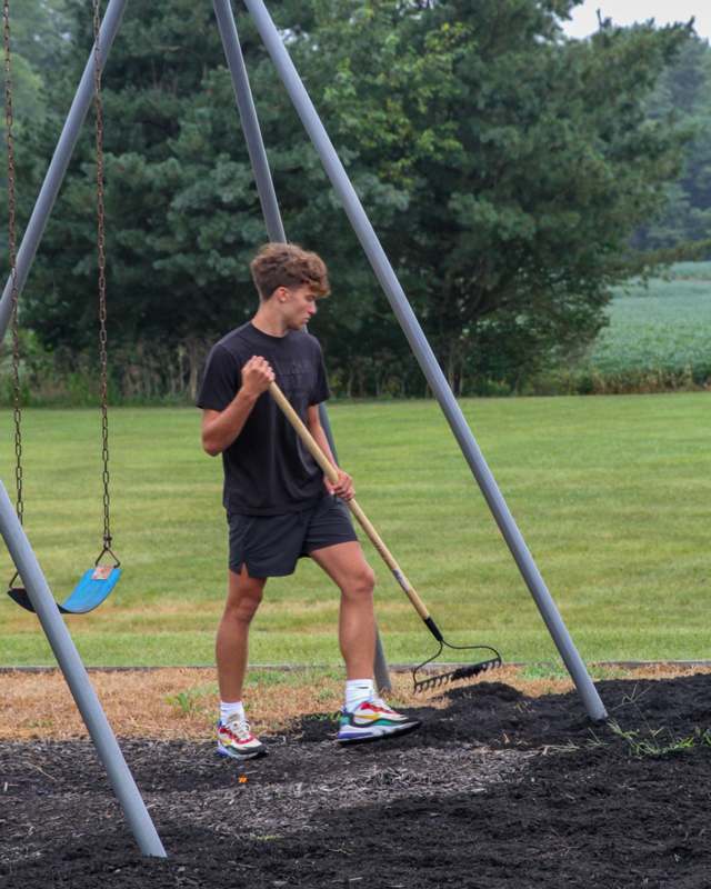 a man holding a rake in a playground