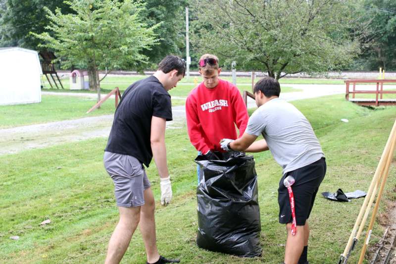 a group of people picking up trash in a bag