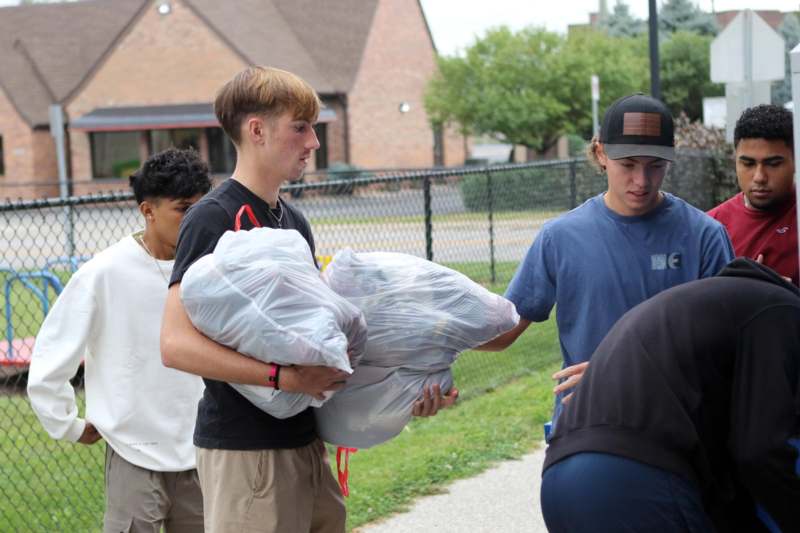 a group of people holding bags of trash