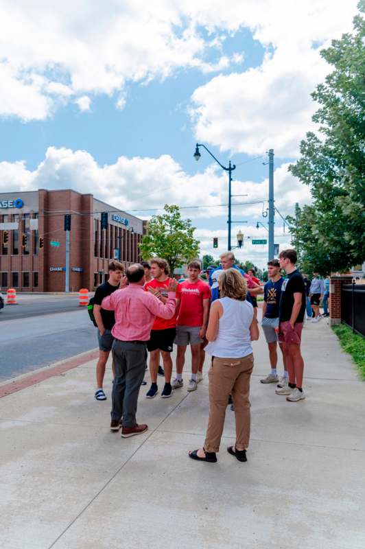 a group of people standing on a sidewalk