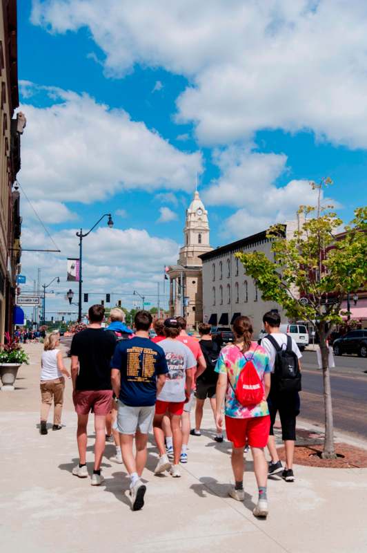 a group of people walking on a sidewalk