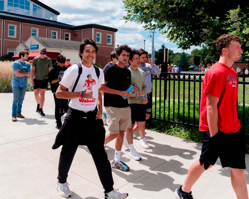 a group of people walking on a sidewalk