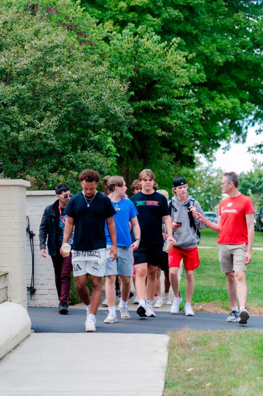 a group of people walking on a sidewalk