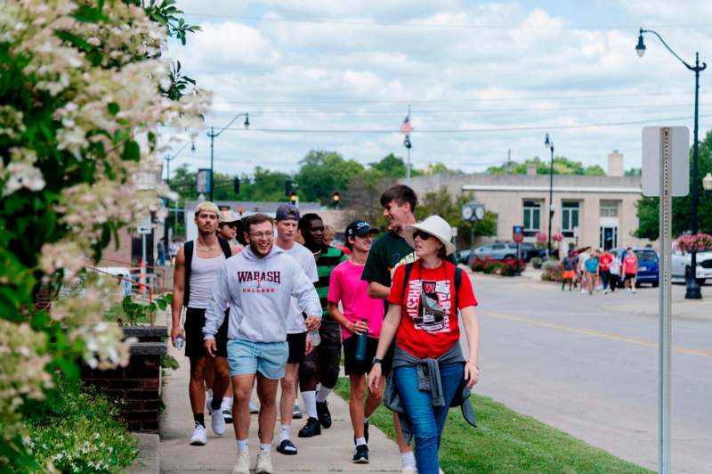 a group of people walking on a sidewalk