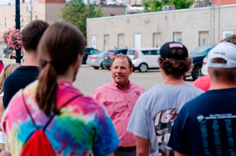 a man in a pink shirt standing in a circle with other people