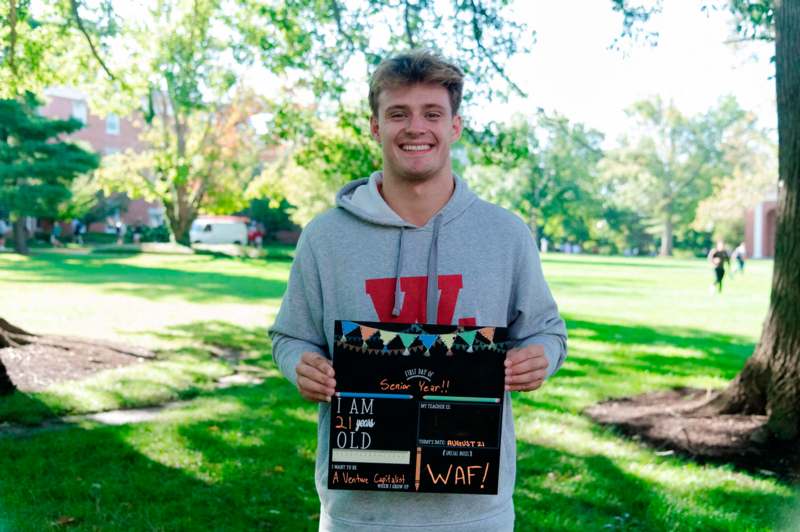 a man holding a sign in a park