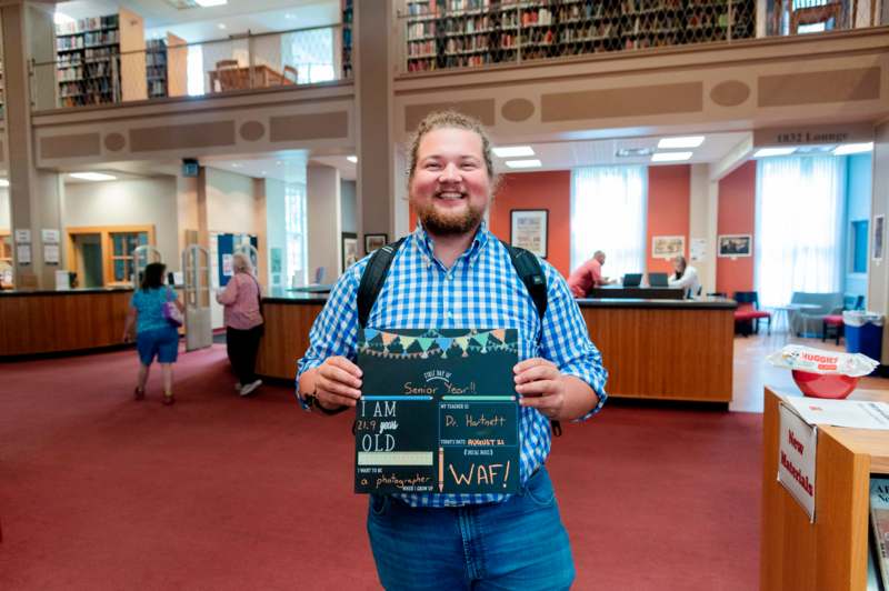 a man holding a sign in a library