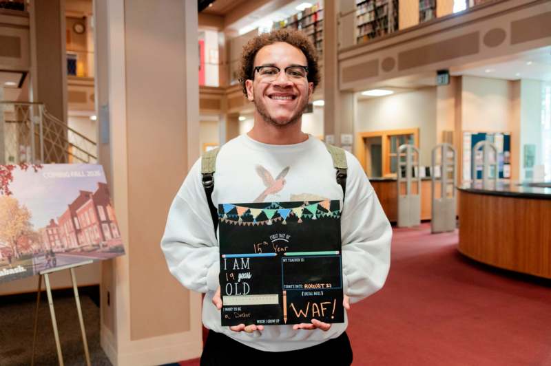 a man holding a book in a library