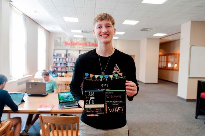 a man holding a sign in a library