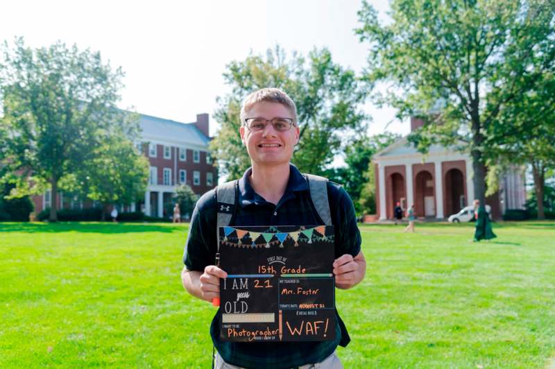 a man holding a sign in front of a building