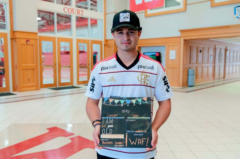 a man holding a sign in a hallway