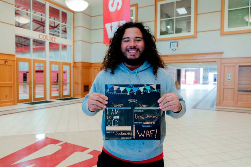 a man holding a sign in a hallway