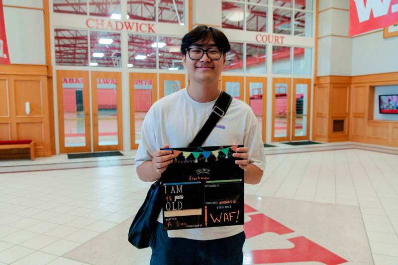 a man holding a sign in a school