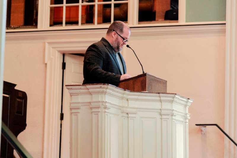 a man standing at a podium with a microphone