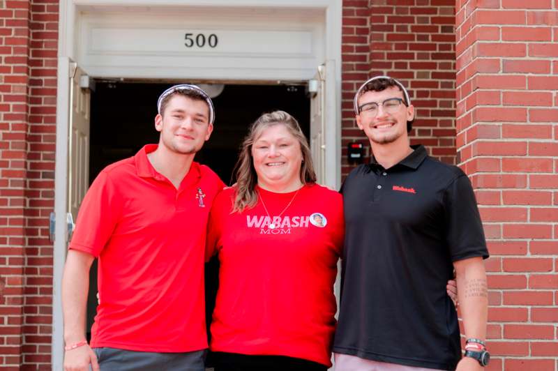 a group of people standing in front of a brick building