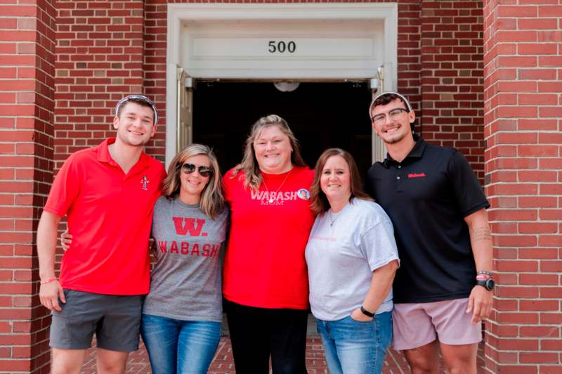 a group of people standing in front of a brick building