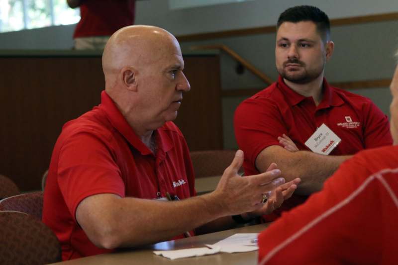 a group of men in red shirts talking